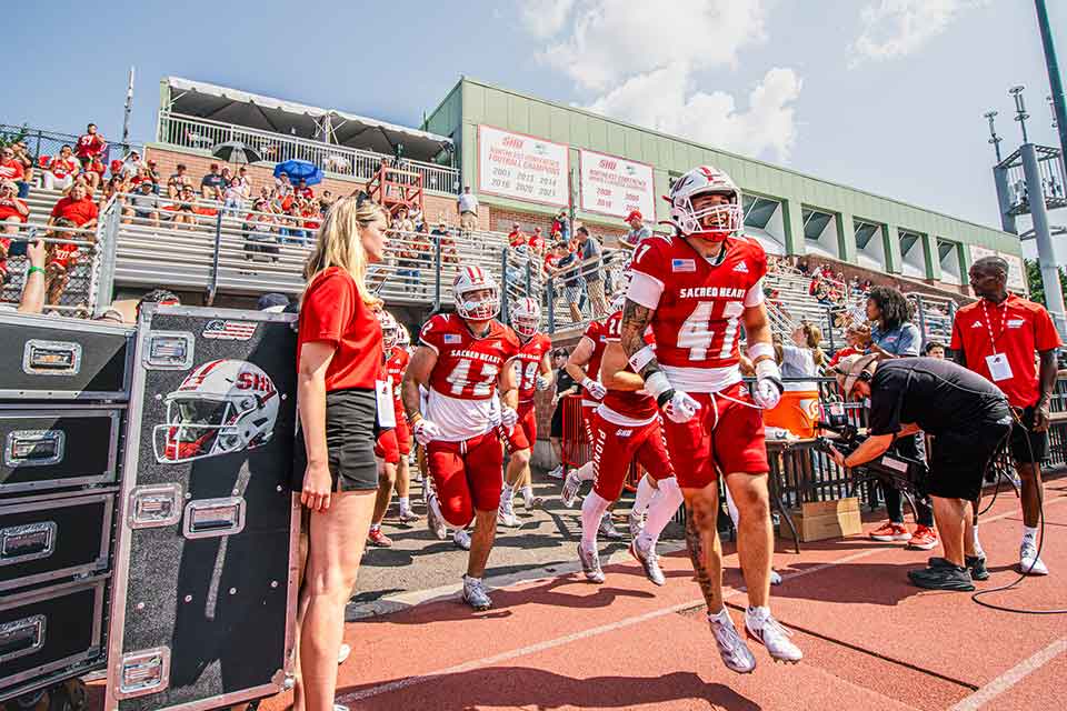 Fans cheer on the Pioneers at the football game during Homecoming Weekend